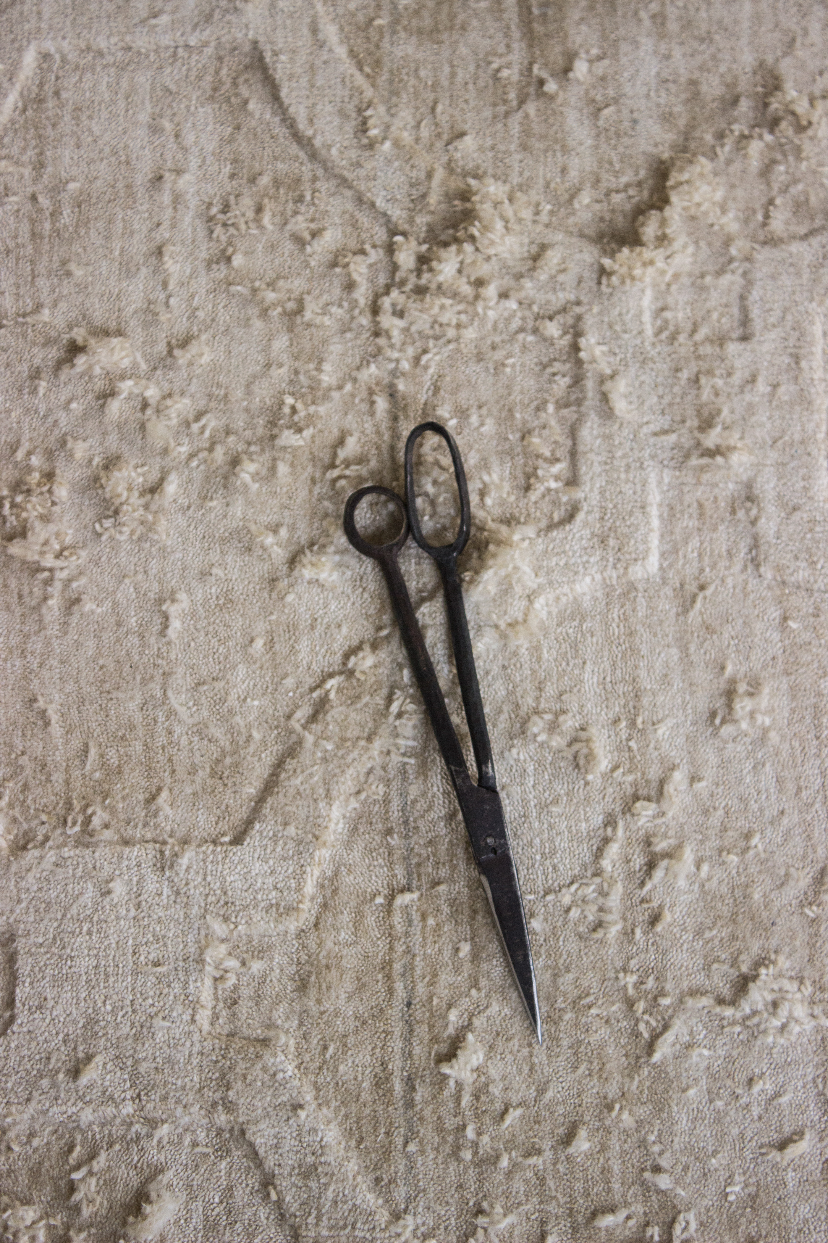 Finishing shears resting on hand-knotted rug