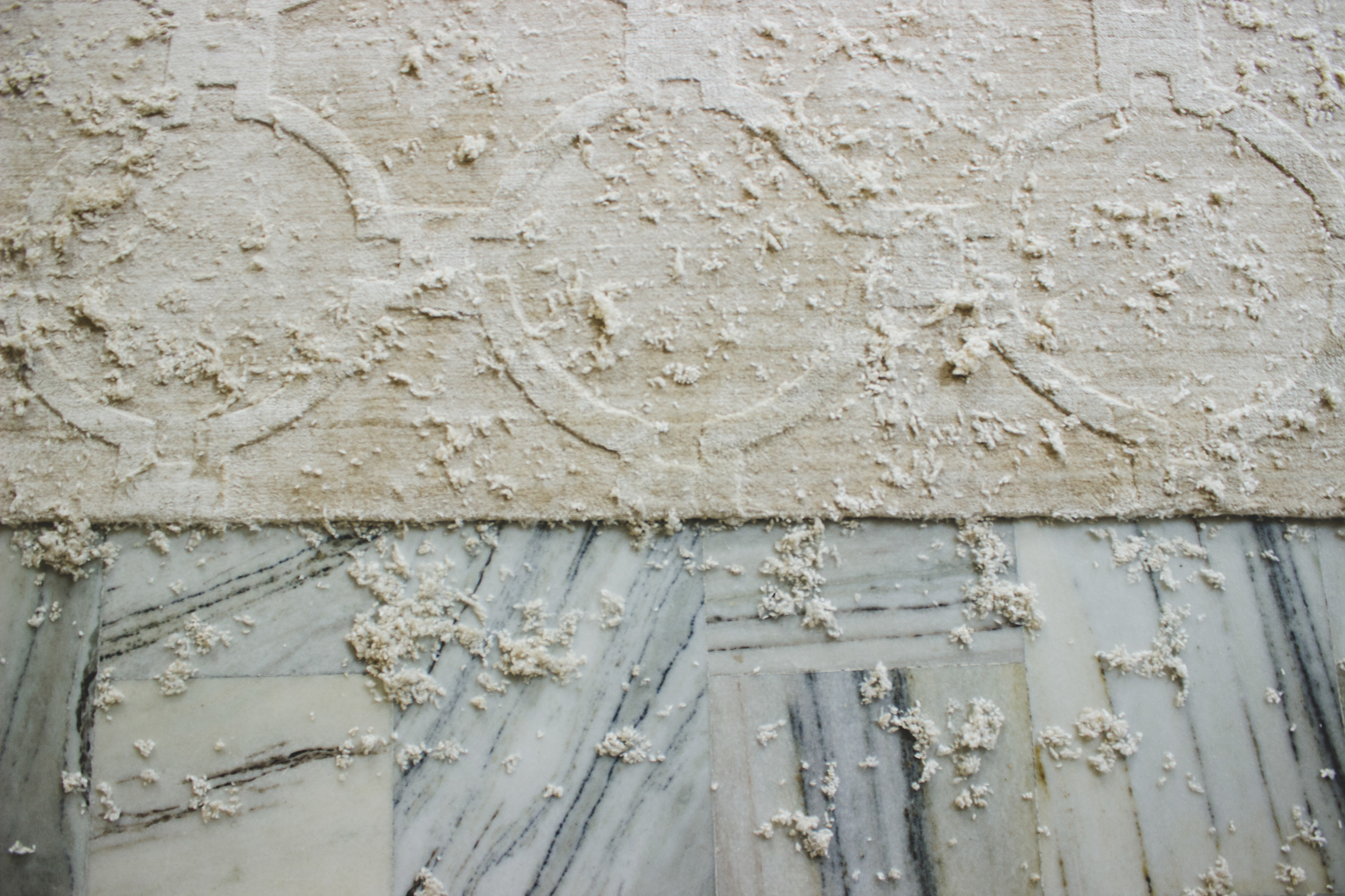 Handcrafted rug resting on marble floor